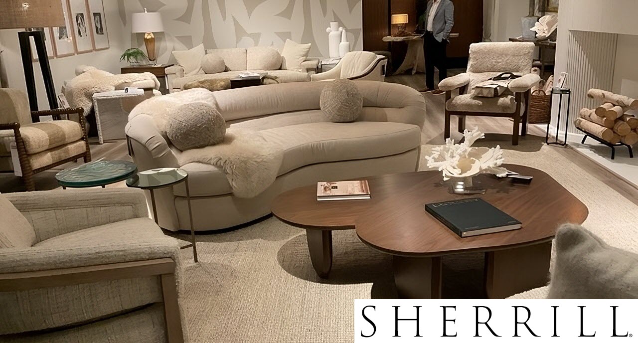 Curved cream sofa with boucle upholstery, modern wood coffee tables, and layered textures in a warm, neutral-toned living room – Spring 2025 interior design trend